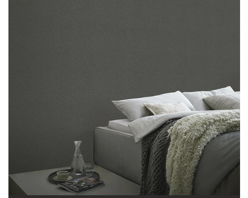 Sovrum med textiltapet, säng och nattduksbord