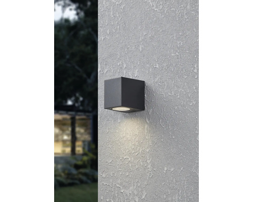 Fyrkantig svart yttervägglampa på en strukturerad vägg