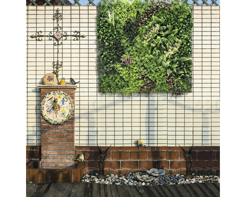 Dekorativ trädgård med vertikal rabatt, ornament och skulpturer