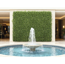 Dekorativ grön vägg med en fontän i förgrunden