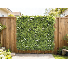 Dekorativ grön panel med vita blommor på ett trästaket