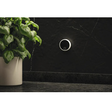 Miljöbild med en vägglampa, en krukväxt och en mörk bänkskiva