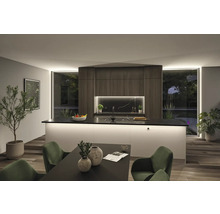 Modernt kök med köksö, matbord och gröna stolar.