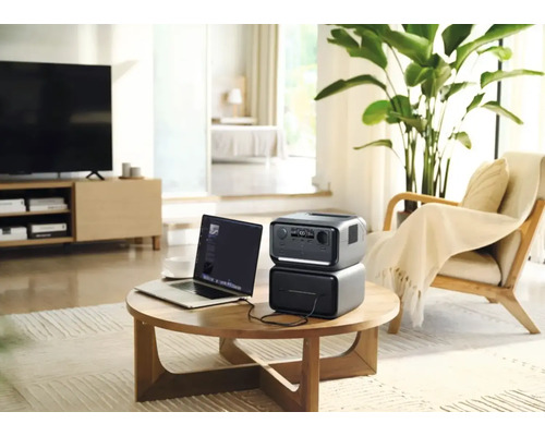 Bärbar kraftstation med bärbar dator på ett bord i ett vardagsrum