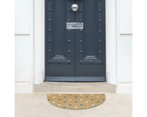 Halvrund dörrmatta framför en ytterdörr med prickmönster