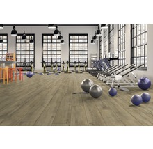 Gym med träningsutrustning och ljust trägolv