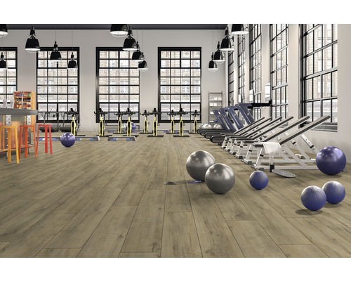 Gym med träningsutrustning och ljust trägolv