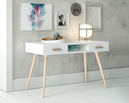 Vitt skrivbord med träben, lådor och förvaringsfack under konst, klocka och lampa