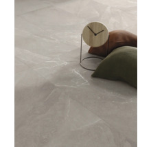 Golvplattor med marmorlook och dekorativa föremål.