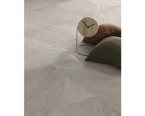 Golvplattor med marmorlook och dekorativa föremål.