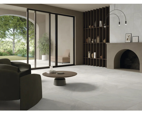 Ljust vardagsrum med klinkergolv, fåtölj, soffbord och vägghylla