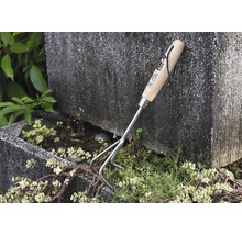 Trädgårdsredskap med trähandtag och tre pinnar för att luckra upp jorden