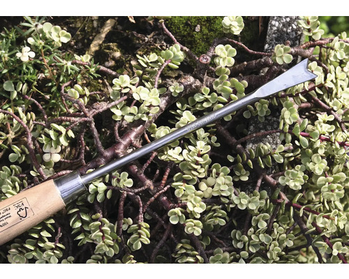 Ogräsjärn med trähandtag framför växter