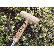 Trädgårdsverktyg med trähandtag och for-q-logotyp, omgiven av växter