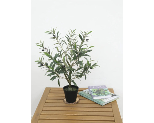 Konstgjort olivträd i kruka på ett träbord