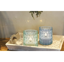 Två dekorativa ljuslyktor i glas på en bricka