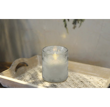 Dekorativt ljus i ett glas på en bricka