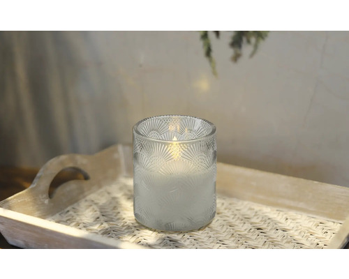 Dekorativt ljus i ett glas på en bricka