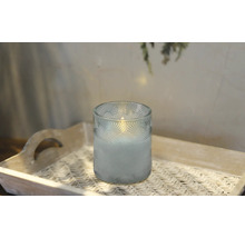 Ljus i glas med mönster på en bricka