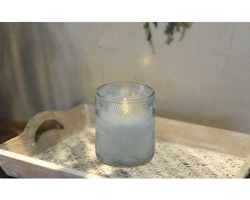 Ljus i glas med mönster på en bricka