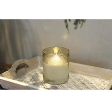 Ljus i ett dekorerat glas på en bricka