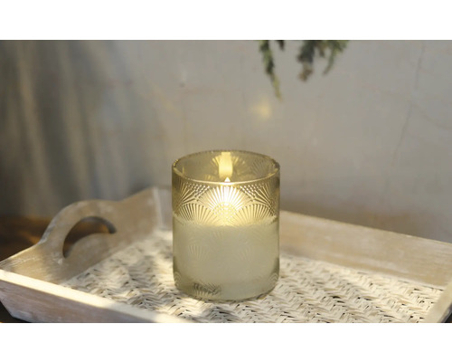 Ljus i ett dekorerat glas på en bricka