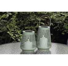 Två dekorativa lyktor med mönster och handtag på ett bord