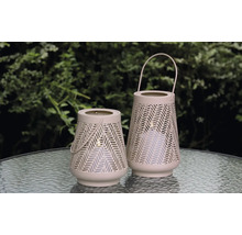 Två dekorativa lyktor med handtag och geometriskt mönster står på ett bord.