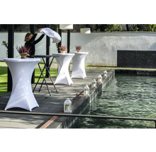 Miljö med ståbord, blomsterdekorationer och lyktor vid en damm