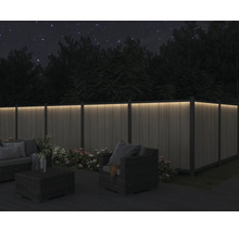 Terrass med upplyst staket och sittgrupp på natten