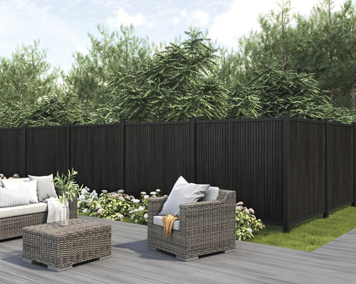 Trädgårdsscen med mörk insynsskydd, loungemöbler och planteringar