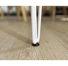 Närbild av ett vitt bordsben med golvskydd på ett trägolv.