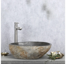 Tvättställ i natursten med armatur på hylla med tvålkopp och dekoration