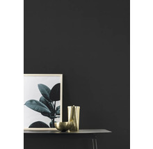 Dekorativ scen med bild, behållare och skål på ett bord.