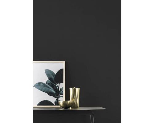 Dekorativ scen med bild, behållare och skål på ett bord.