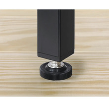 Detaljvy av ett svart bordsben med justerbar fot på ett trägolv.