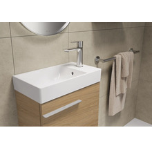 Tvättställ med blandare, handdukshållare och handduk i ett badrum