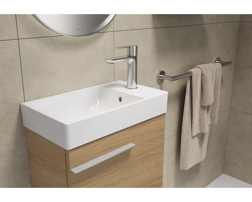 Tvättställ med blandare, handdukshållare och handduk i ett badrum