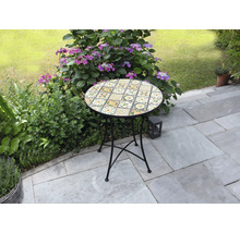 Runt trädgårdsbord med mosaikmönster på en terrass