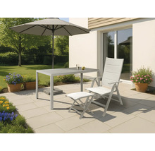 Trädgårdsscen med bord, stol, fotpall och parasoll på en terrass