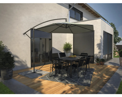 Terrass med parasoll, bord och stolar på trägolv med matta