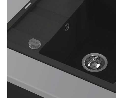 Detaljvy av en svart diskho med avlopp och manöverknapp