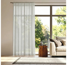 Vardagsrum med gardin framför fönstret, soffa och matta