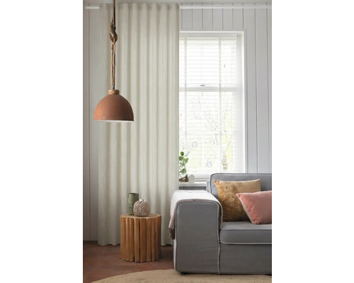 Vardagsrum med grå soffa, sidobord i trä och tyggardin