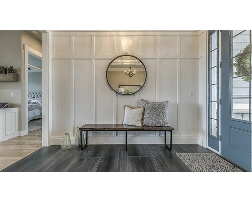 Entré med spegel, bänk och dekorativa kuddar på väggen