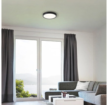 Vardagsrum med taklampa och stora fönster