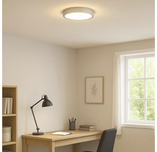 Belyst arbetsrum med taklampa, skrivbord och fönster.