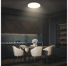 Matsal med matbord, stolar och rund taklampa