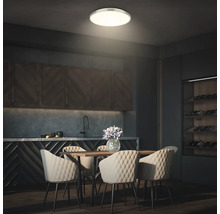 Matsal med matbord, stolar och rund taklampa