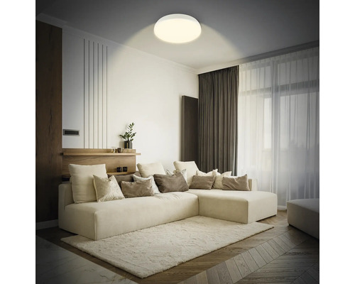 Vardagsrum med soffa, matta och rund taklampa